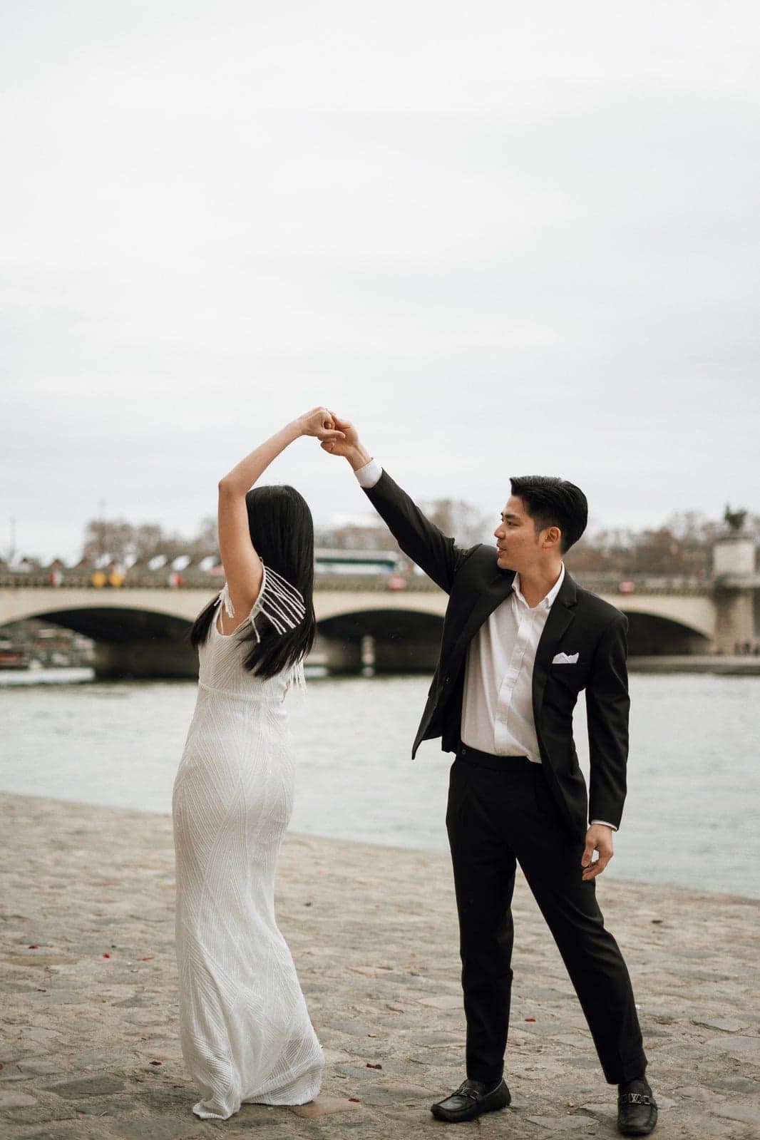 Suthida twirling with Thanapat beside the River Seine